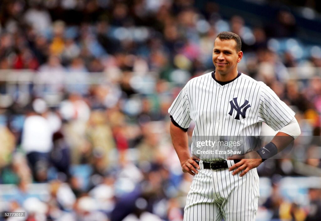 Alex Rodriguez on a baseball field looking smug with his hands on hips.