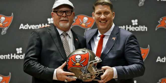 New NFC South coach Bruce Arians holds the helmet of his new team, the Tampa Bay Buccaneers