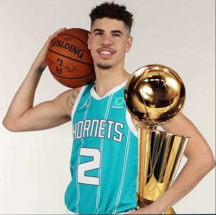 LaMelo Ball holding the Larry O' Brian trophy.