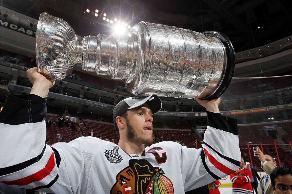 On-ice photo of Jonathon Toews holding the Stanley Cup above his head in 2010