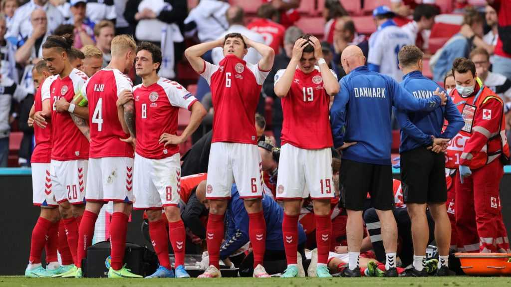 Christian Eriksen is tended to as his Denmark teammates create a ring around him to shield him from view.