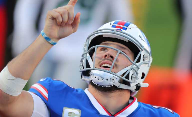 Buffalo Bills quarterback and current second highest-paid player Josh Allen pointing to the sky "pictured here"