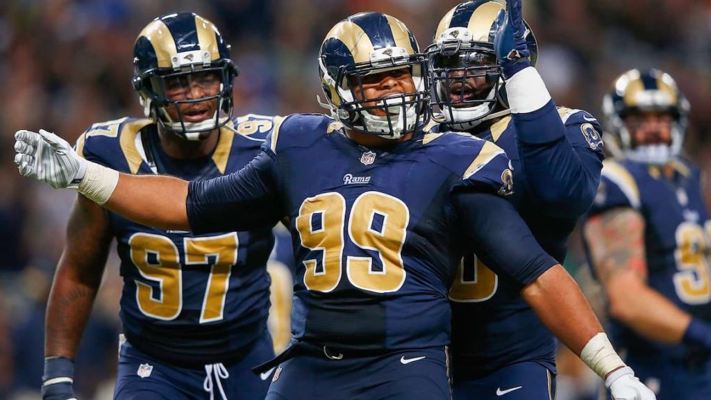 Rams defensive lineman Aaron Donald celebrating with teammates on the field after a play. "pictured here"