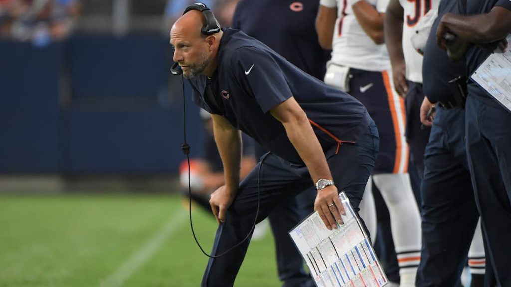 Chicago Bears head coach Matt Nagy with his hands on his knees standing in front of his team's sideline during a game. "pictured here"