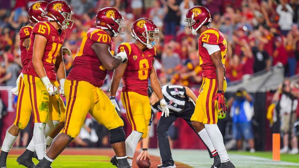 A few USC football players grouped together on the field during a game. "pictured here"
