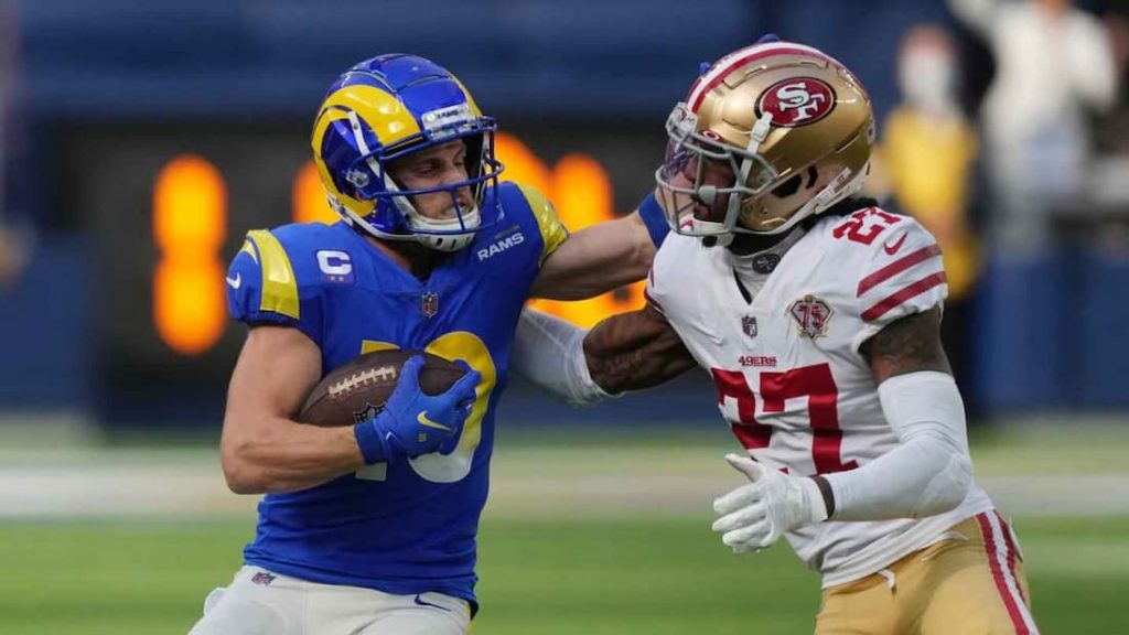 Los Angeles Rams wide receiver Cooper Kupp fighting off a San Francisco 49ers defensive back during a game. "pictured here" 