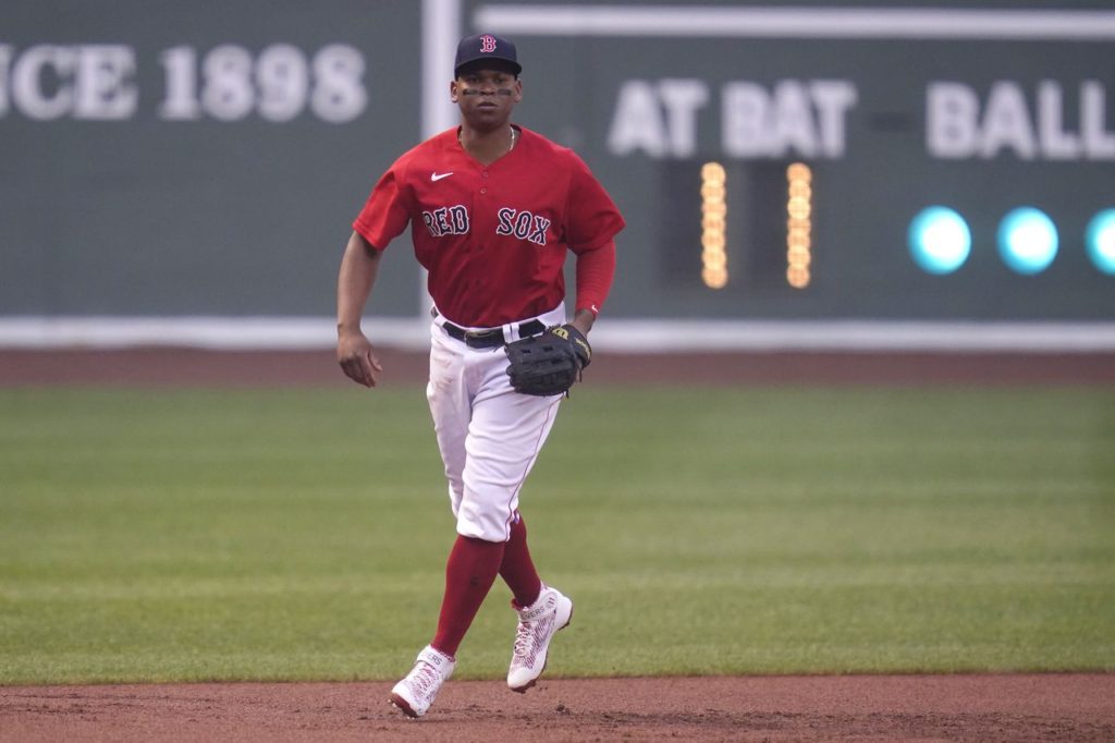 Boston Red Sox Rafael Devers at third base in Boston's alternate jerseys with white pants and red tops with blue lettering. Will subpar defense complicate Rafael Devers' contract extension with the Red Sox? 
