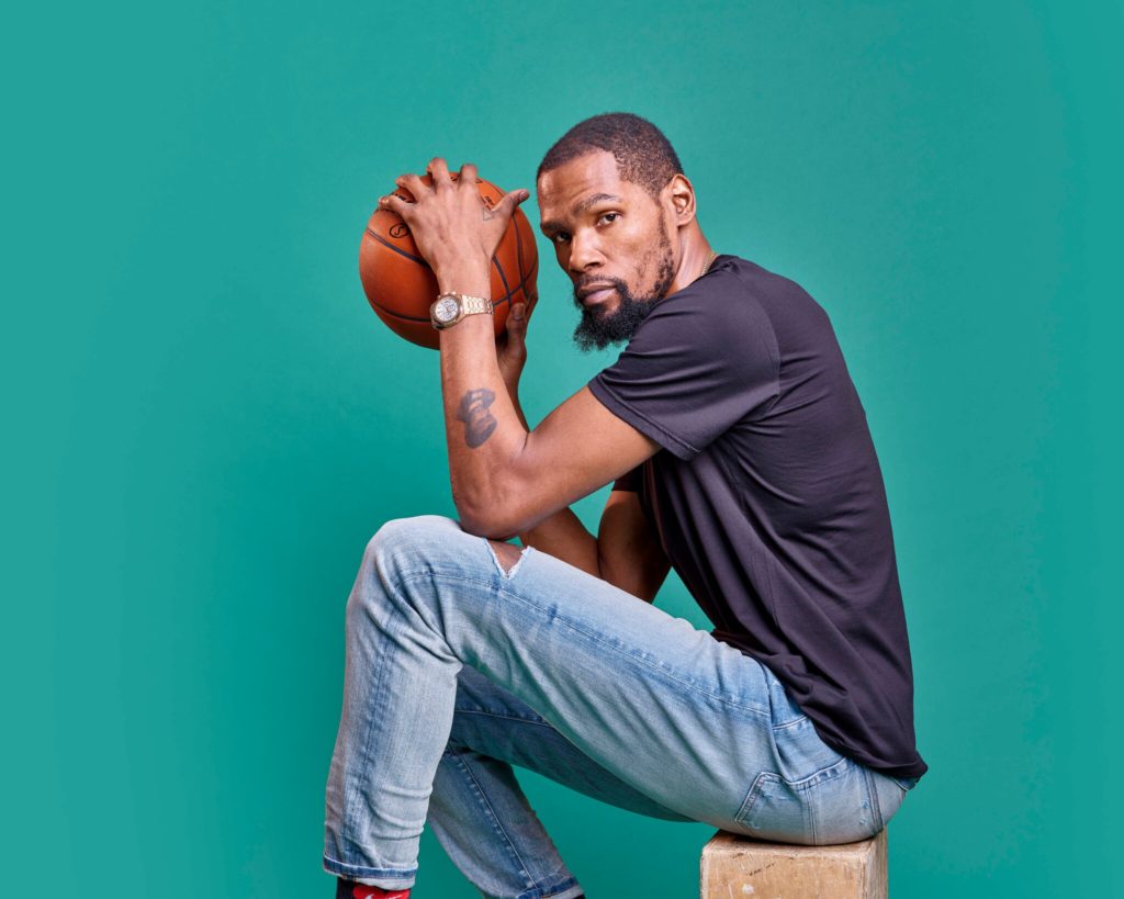 Kevin Durant sitting and hold a baskeball.