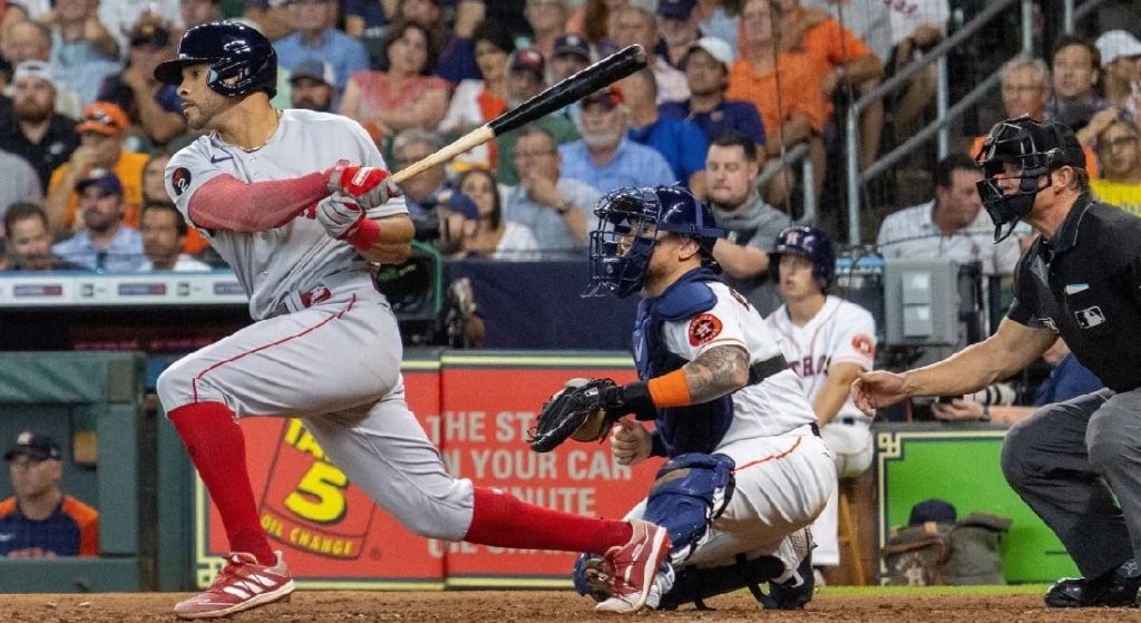 Tommy Pham, acquired by the Red Sox in a third of four deals at the trade deadline, was a desperately needed outfield bat made lesser by the release of Jackie Bradley Jr. Pictured: Pham at bat in his first game as a Red Sox. he is wearing Boston's gray road jersey with red and gray batting gloves, a red arm sleeve, and red socks and cleats. Christian Vasquez is also pictured, catching his first game as an Astro. Vasquez is wearing Houston's home white jersey with blue catching gear. 