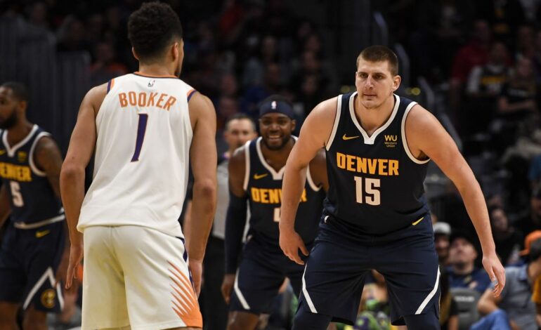 Suns Guard Devin Booker being defended by Nuggets Center Nikola Jokic