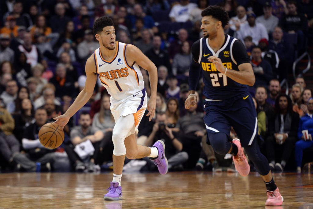 Suns Guard Devin Booker being guarded by Nuggets Guard Jamal Murray