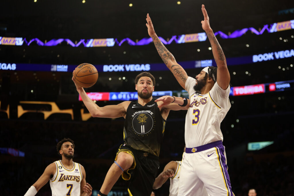 Lakers Davis trying to block Warriors Thompson's shot.