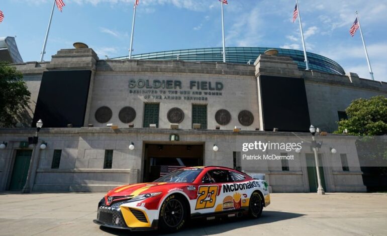 CHICAGO, ILLINOIS - JULY 19: Bubba Wallace drives in front of Soldier Field in promotion of the NASCAR Chicago Street Race announcement on July 19, 2022 in Chicago, Illinois. (Photo by Patrick McDermott/Getty Images)